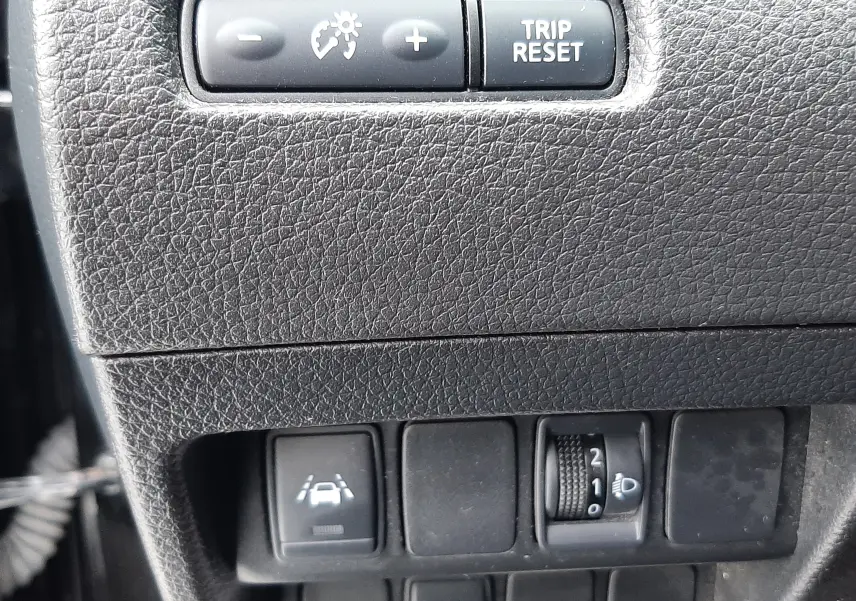 Détail du tableau de bord noir du Nissan Qashqai DCI 115 N-Connecta 2020 montrant les commandes de régulateur, assistance de voie et réglage des phares.