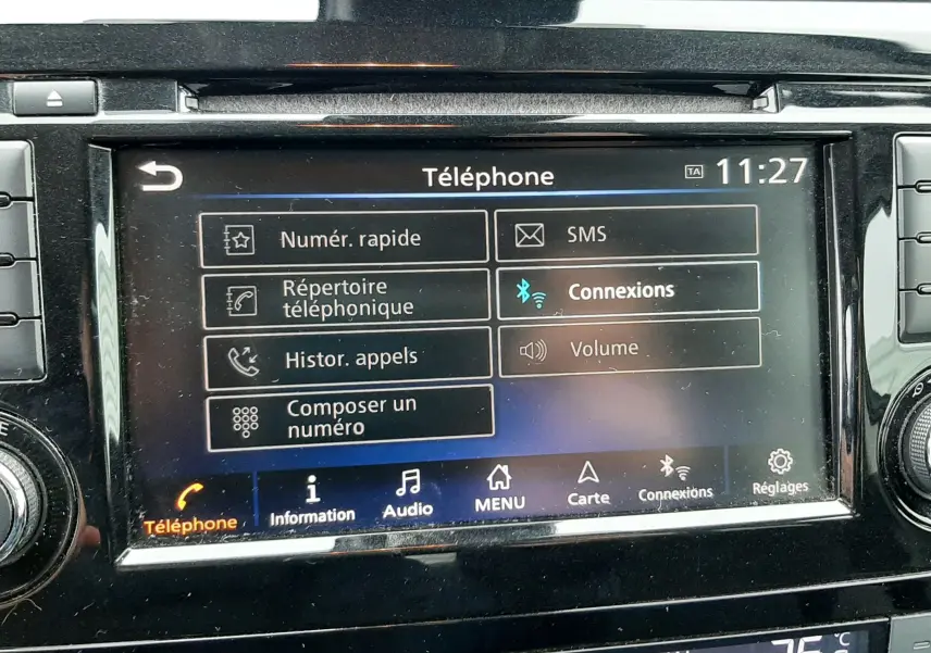 Écran tactile central du Nissan Qashqai noir 2020, affichant le menu téléphone avec commandes climatisation en dessous.