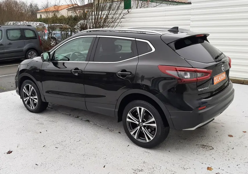 Vue 3/4 arrière droite d'un Nissan Qashqai noir 2020 avec jantes alliage bicolores et vitres teintées.