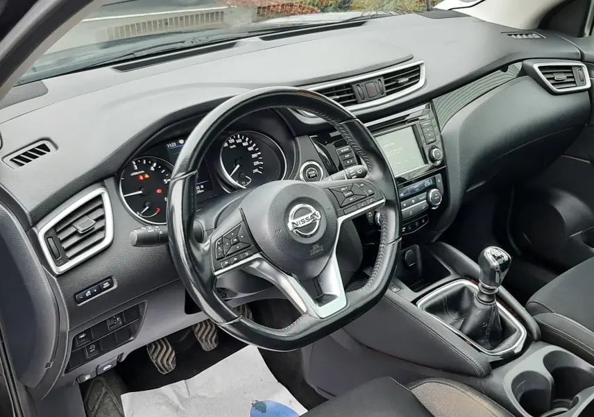 Vue intérieure côté conducteur du Nissan Qashqai noir 2020, volant multifonction et boîte manuelle visible.