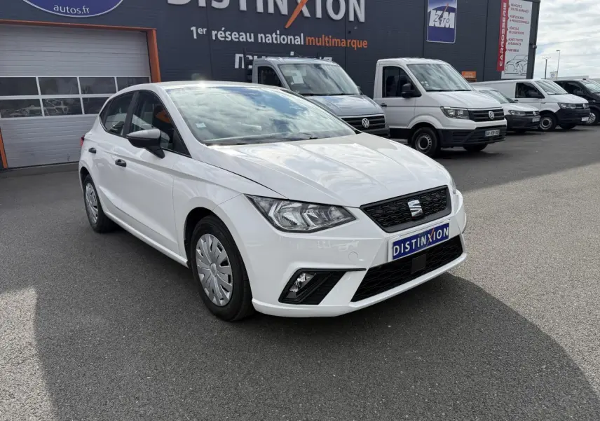 SEAT Ibiza blanc Candy vue 3/4 avant droit, avec phares antibrouillard et enjoliveurs 15 pouces visibles.