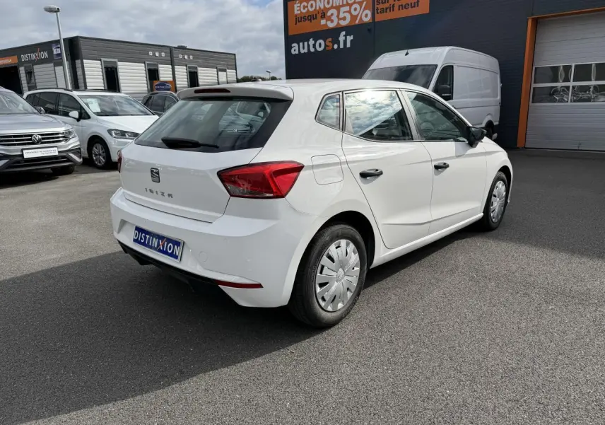 SEAT Ibiza blanc candy vue 3/4 arrière droit, avec enjoliveurs de roue et rétroviseurs noirs visibles.