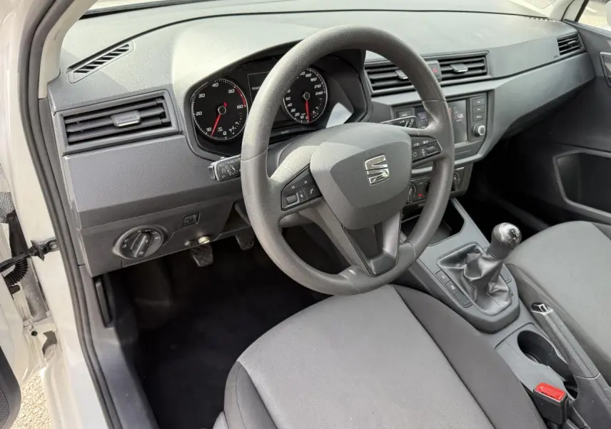 Intérieur côté conducteur de la SEAT Ibiza blanc Candy 2019, volant multifonction et boîte manuelle visibles.