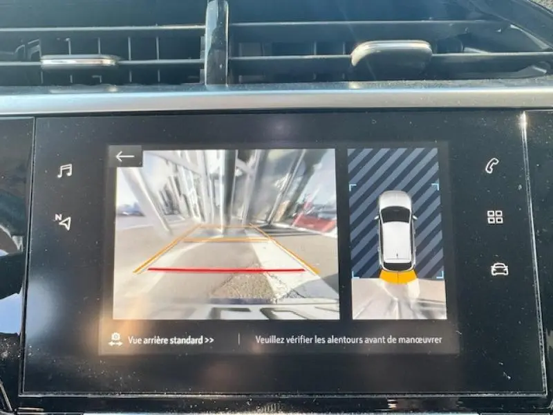 Écran tactile de l'Opel Corsa 1.2 Turbo 2022 montrant la caméra de recul et l'alerte de proximité arrière.
