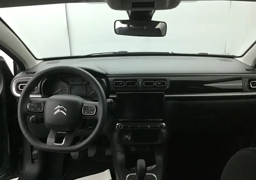 Vue intérieure frontale du tableau de bord noir brillant et volant multifonction de la Citroën C3 2022.