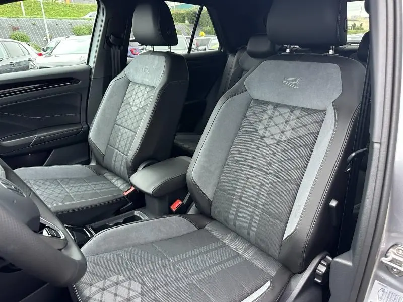 Vue intérieure côté gauche des sièges avant gris artvelours avec logo R sur le dossier du Volkswagen T-Roc 2025.