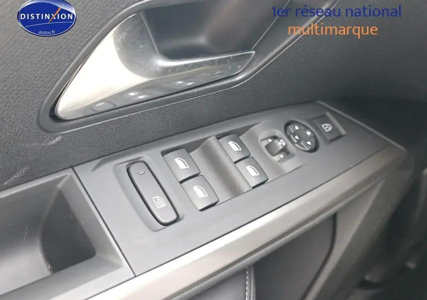 Vue rapprochée des commandes de lève-vitres côté gauche intérieur d'une Peugeot 3008 bleu 2025.