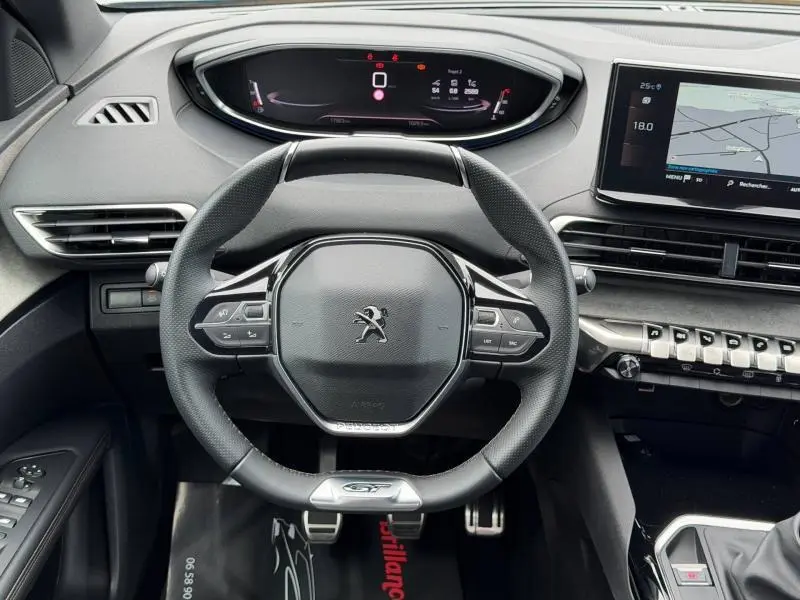 Vue intérieure centrée sur le volant compact du Peugeot 3008 GT avec tableau de bord numérique et écran tactile.