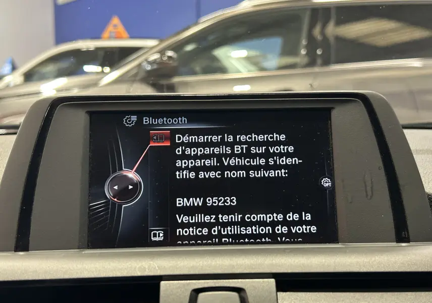 Écran central de la BMW Série 1 16d 2014 affichant le menu Bluetooth pour appairage des appareils.