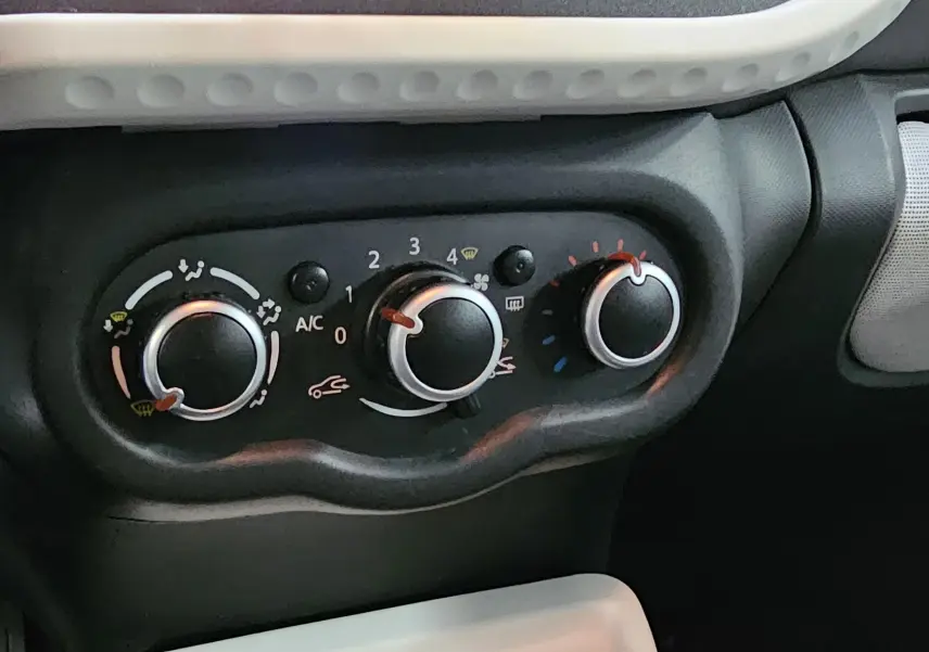 Gros plan sur les commandes de climatisation d'une Renault Twingo III gris lunaire, version 1.0i SCe 70 LIMITED de 2018.