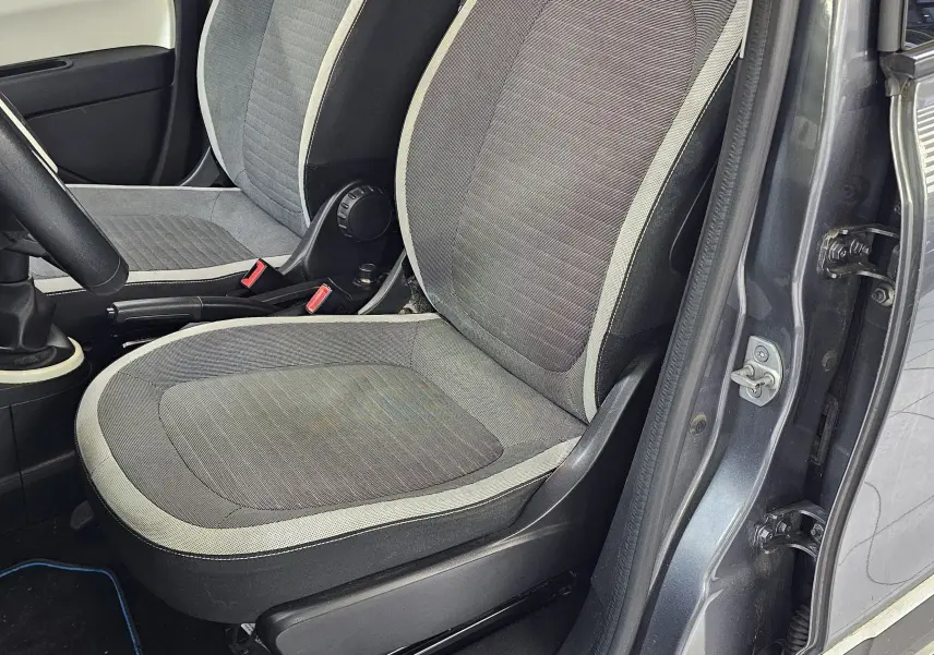 Intérieur de la Renault Twingo III gris lunaire, vue côté conducteur avec sièges tissu gris et volant noir.