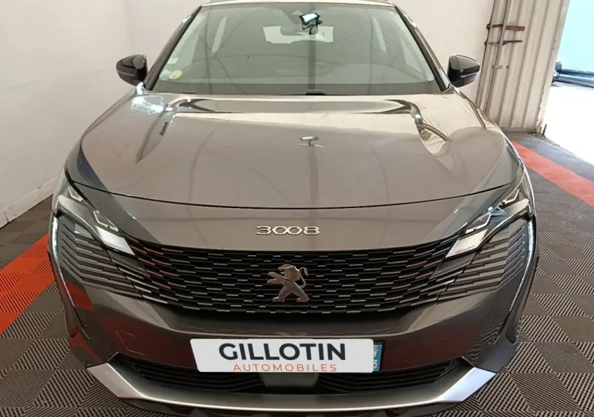 Vue frontale d’un Peugeot 3008 gris foncé avec calandre noire et phares LED distinctifs.