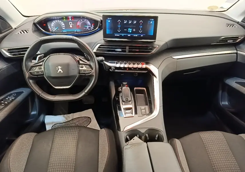 Vue intérieure avant du Peugeot 3008 2022, tableau de bord moderne avec écran tactile et volant cuir multifonctions.