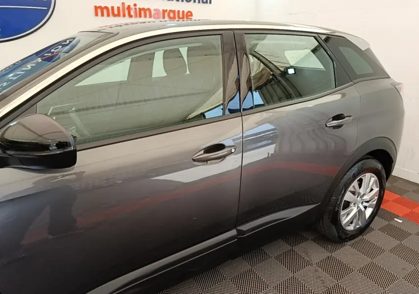 Vue latérale droite d'un Peugeot 3008 gris foncé avec rétroviseurs noirs et jantes alliage visibles.