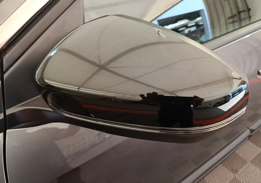 Gros plan sur le rétroviseur droit gris foncé brillant du Peugeot 3008, reflet d’un espace intérieur.