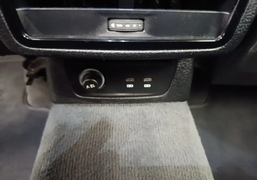 Vue rapprochée des prises USB-C et prise 12V noires sur la console centrale de l'Audi Q3 hybride rechargeable 2023.