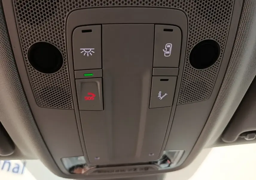 Vue en plongée sur le panneau de commandes au plafond de l'Audi Q3 45 TFSI e avec bouton SOS rouge allumé.
