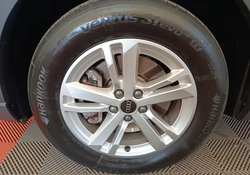 Gros plan sur la roue avant droite d’un Audi Q3 45 TFSI e avec jante argentée et pneu Hankook noir.
