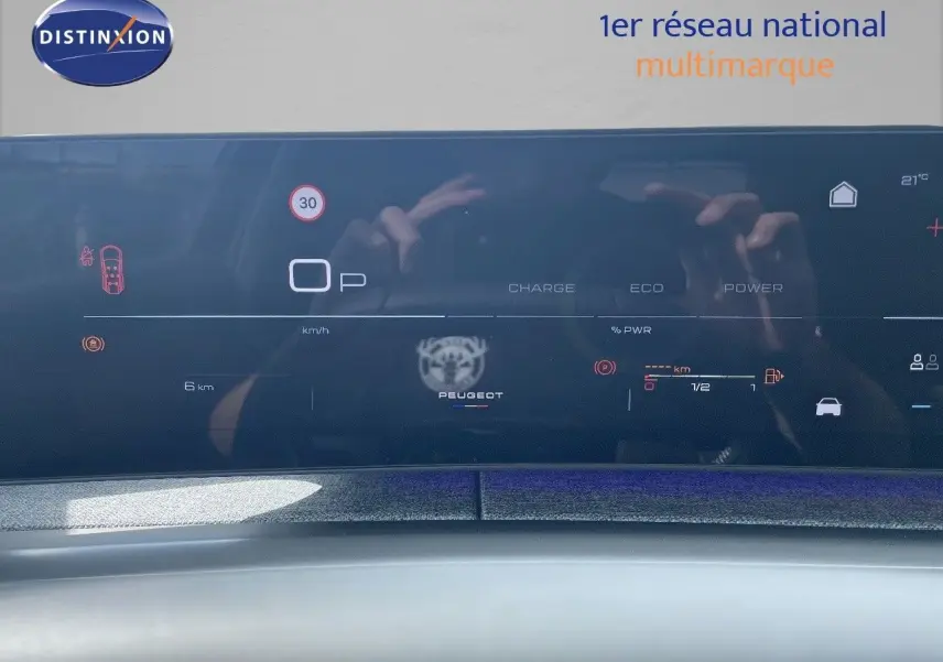 Tableau de bord numérique du Peugeot 5008 noir métal 2025 affichant vitesse, charge et autonomie en mode hybride.