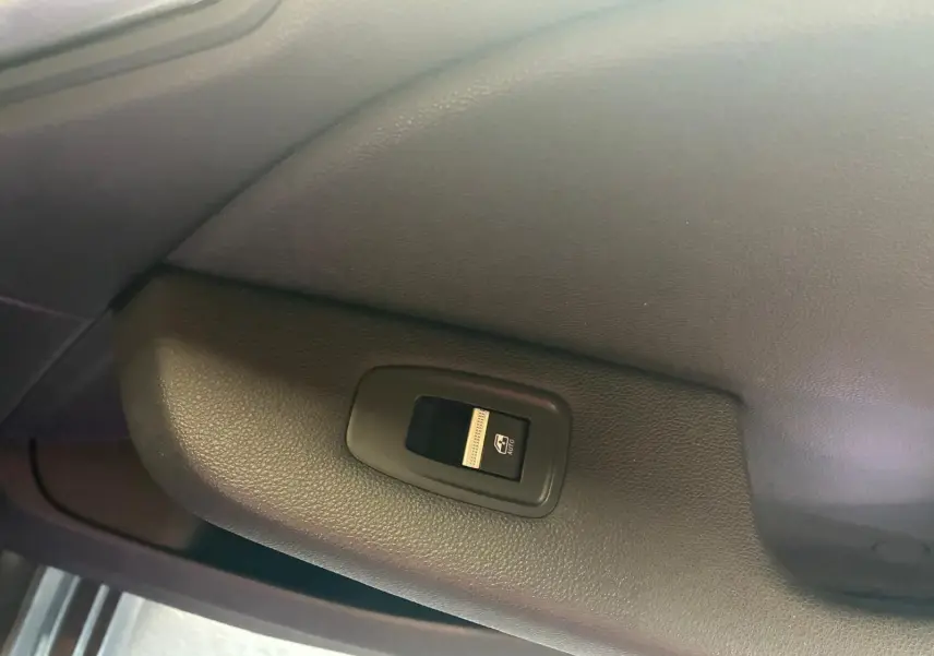 Bouton de commande de lève-vitre électrique sur la porte intérieure côté gauche d'une Renault Clio gris 2020.