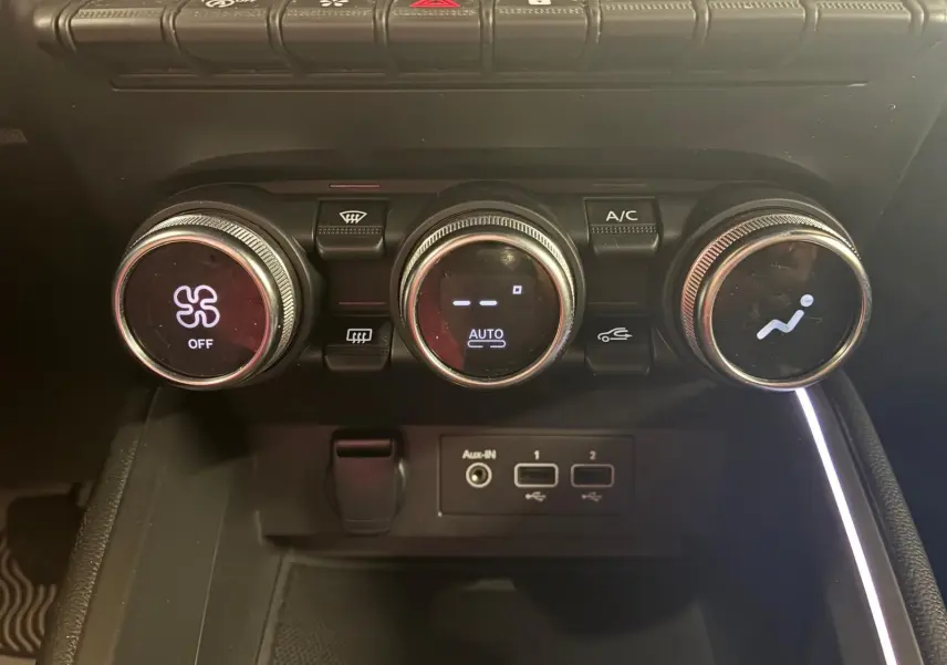 Gros plan sur les commandes de climatisation et les ports USB d'une Renault Clio 1.0 TCE 100 Intens gris, année 2020.