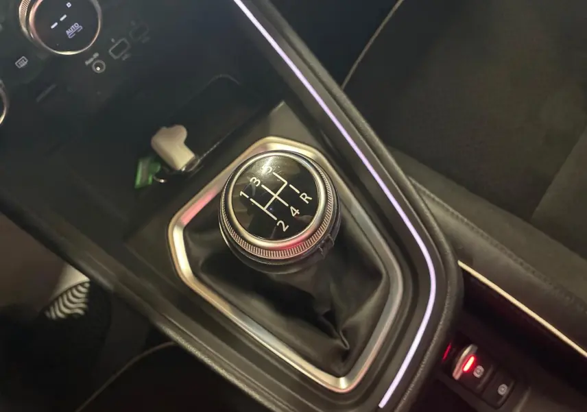 Le levier de vitesses manuel noir de la Renault Clio 1.0 TCE 100 Intens 2020, entouré d'un éclairage d'ambiance violet.