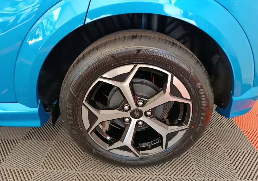 Gros plan sur la roue avant droite du Ford Puma bleu 2025 avec jante alliage noire et argentée.