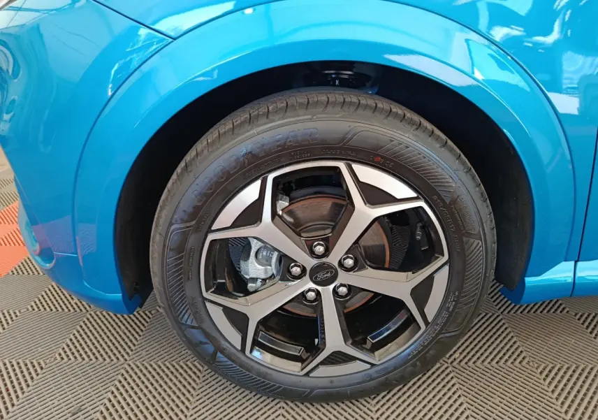 Gros plan sur la roue avant droite du Ford Puma bleu 2025 avec jante alliage noire et argentée.