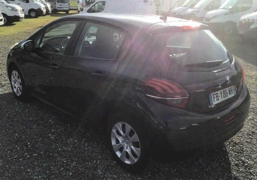 Vue 3/4 arrière droite d'une Peugeot 208 noire de 2018, avec feux arrière caractéristiques et jantes argentées.