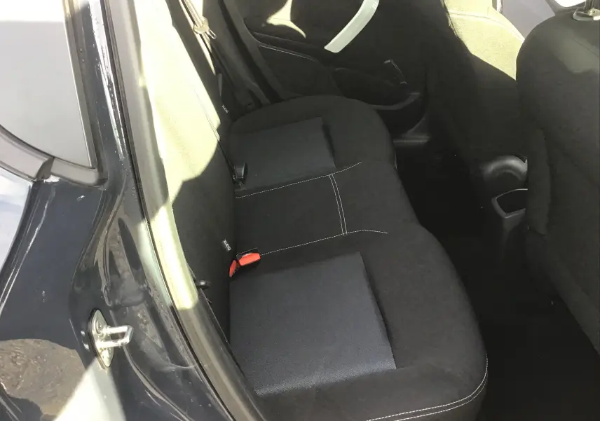 Vue intérieure côté gauche des sièges arrière noirs avec surpiqûres blanches d'une Peugeot 208 2018 essence.