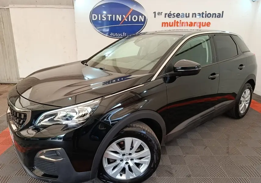 Peugeot 3008 noir vue 3/4 avant droit, avec jantes argentées et calandre distinctive en showroom intérieur.