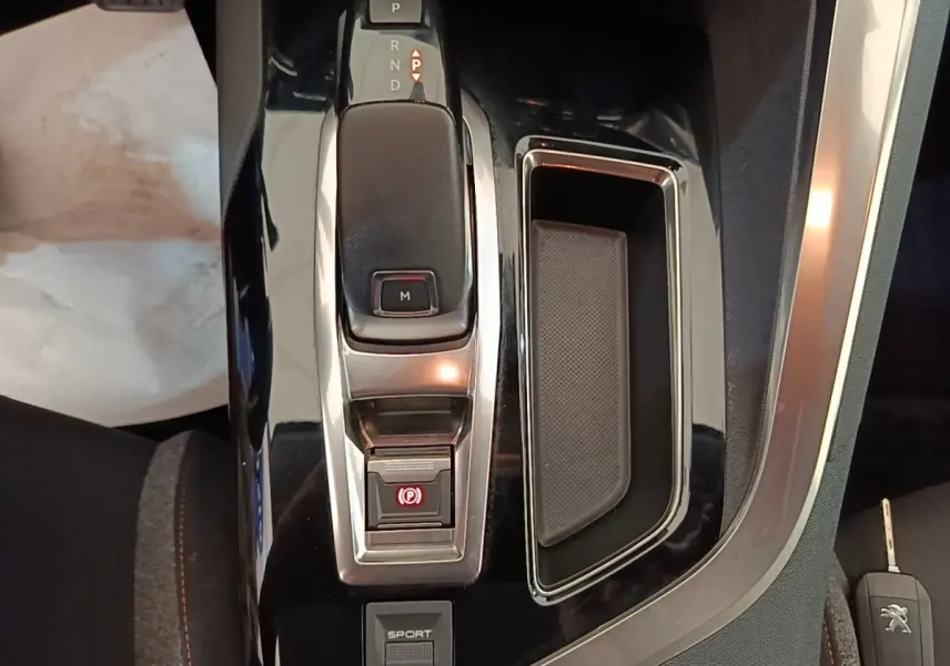 Vue rapprochée de la console centrale noire du Peugeot 3008 avec levier de boîte automatique et bouton sport.