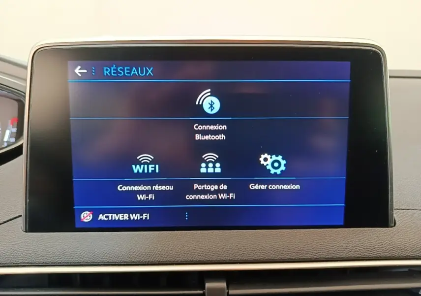 Écran tactile central du tableau de bord du Peugeot 3008 noir, affichant les options de connexion réseau Wi-Fi et Bluetooth.