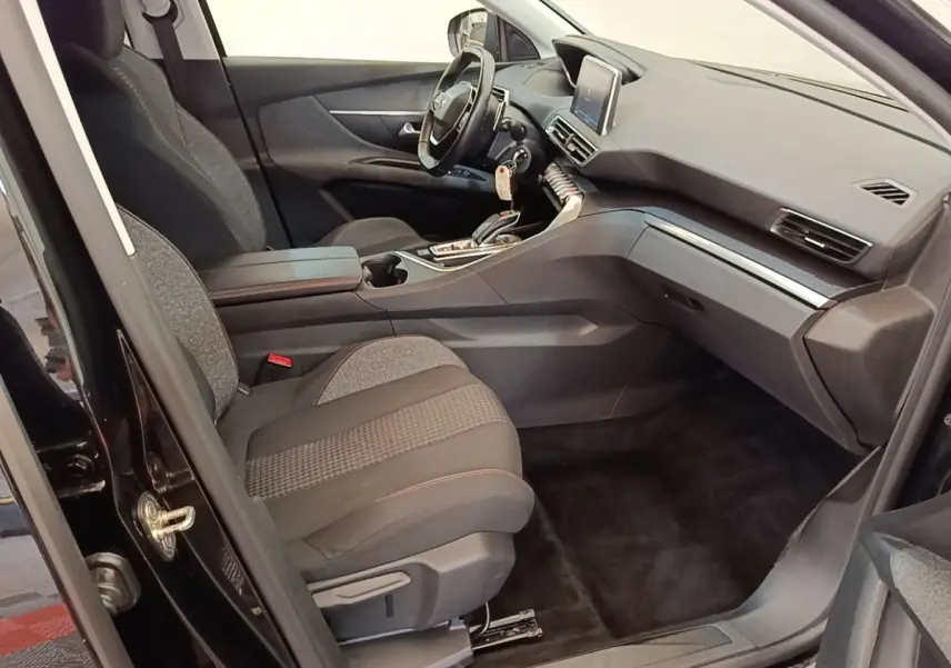 Vue intérieure côté conducteur du Peugeot 3008 noir, mettant en valeur le volant cuir multifonctions et l’écran tactile central.