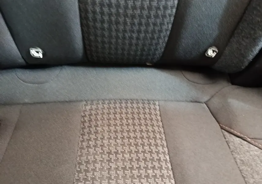 Gros plan sur la banquette arrière noire du Peugeot 3008, tissu à motif et fixations Isofix visibles.