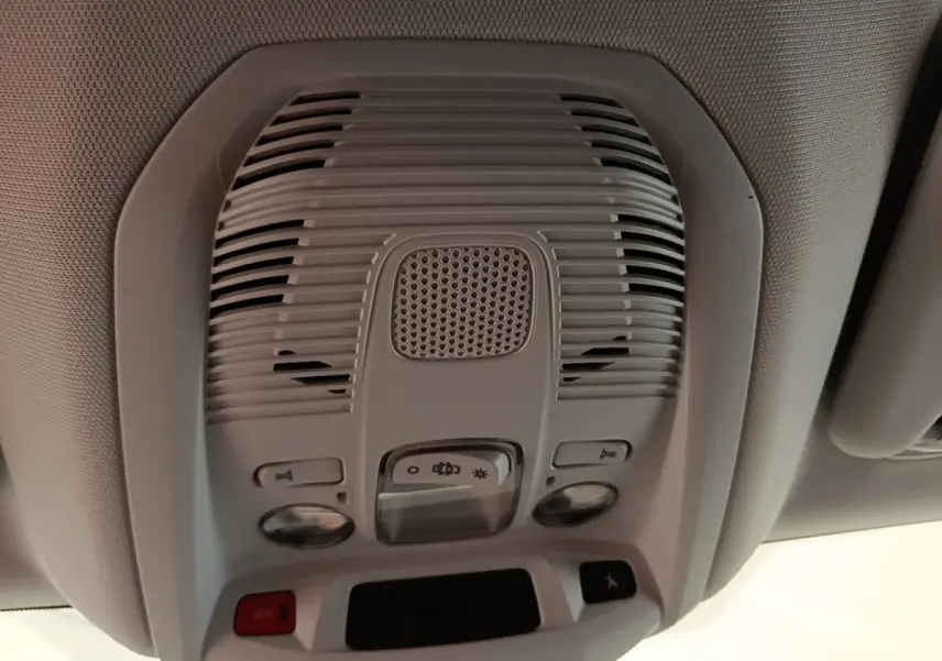 Vue en gros plan du plafonnier gris clair avec commandes d’éclairage et haut-parleur dans un Peugeot 3008 noir.