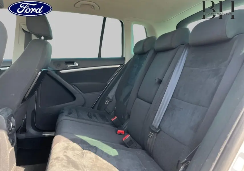 Vue intérieure de la banquette arrière noire du Volkswagen Tiguan 2013, côté droit avec ceintures visibles.