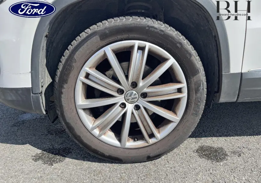 Gros plan sur la roue avant gauche avec jante alu 17 pouces du Volkswagen Tiguan blanc Candy de 2013.
