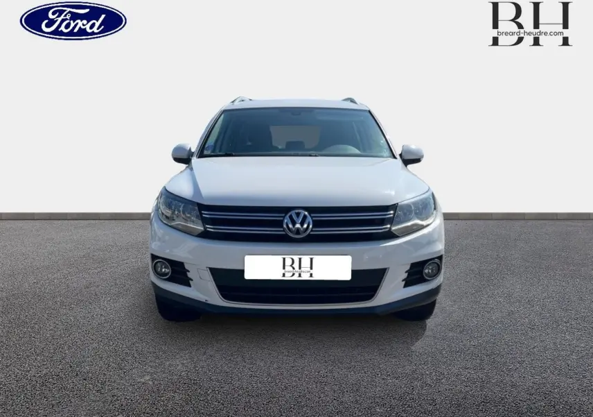 Vue de face du Volkswagen Tiguan blanc Candy 2013 avec calandre chromée et phares halogènes.