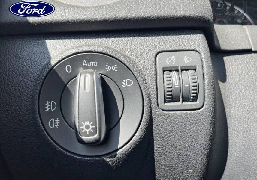 Image montrant le tableau de bord d'une Ford avec commandes d'éclairage et réglages de phares en gros plan.