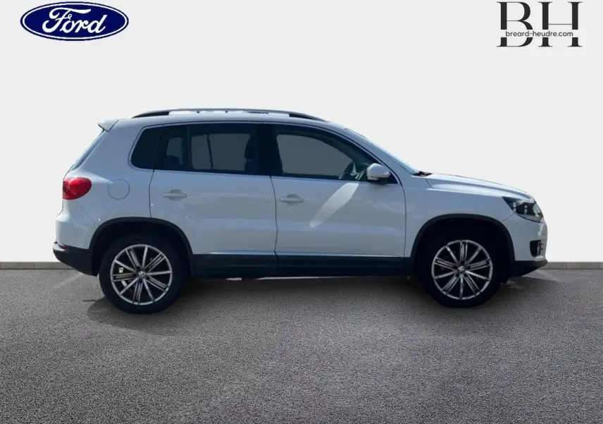 Vue de profil côté gauche d'un Volkswagen Tiguan blanc Candy avec jantes alliage 17 pouces sur fond neutre.