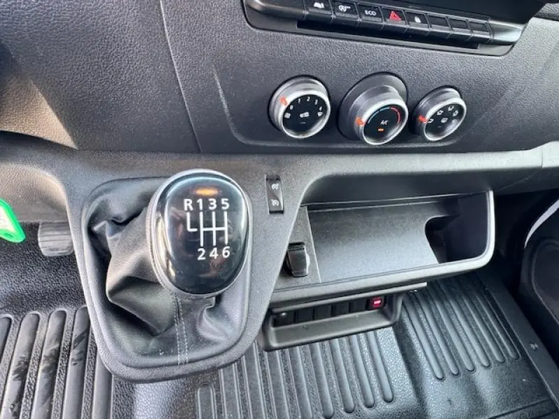 Gros plan sur levier de vitesses manuel et commandes de climatisation du Renault Master Combi blanc 2020.