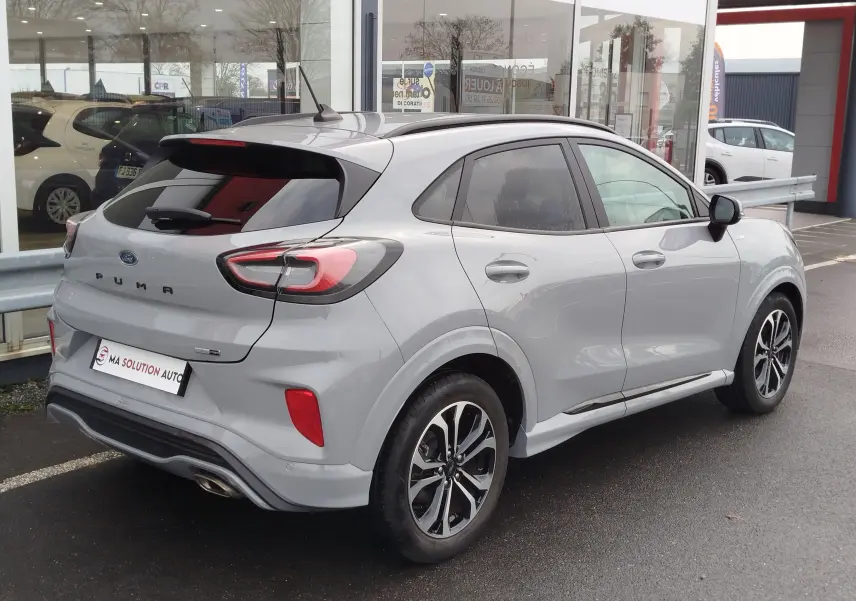 Ford Puma 1.0 EcoBoost gris Fashion, vue 3/4 arrière droit, avec jantes bi-ton et vitres teintées.