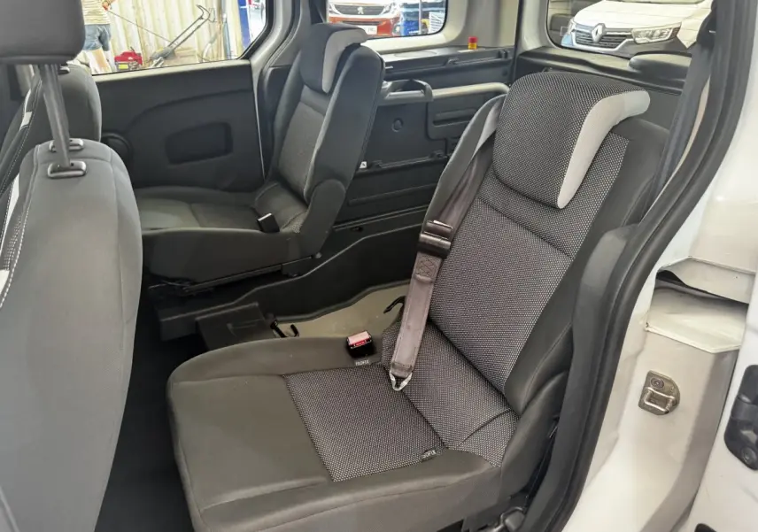 Vue intérieure côté droit sur les sièges arrière gris du Renault Kangoo blanc, avec ceintures de sécurité visibles.