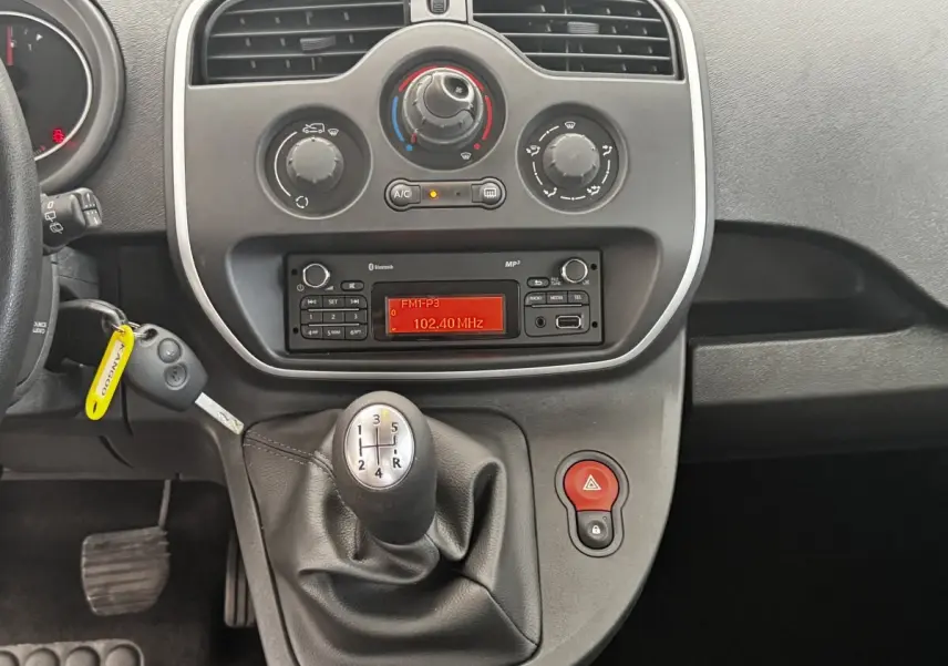 Vue rapprochée de la console centrale du Renault Kangoo Zen 2016 avec levier de vitesse manuel et radio allumée.