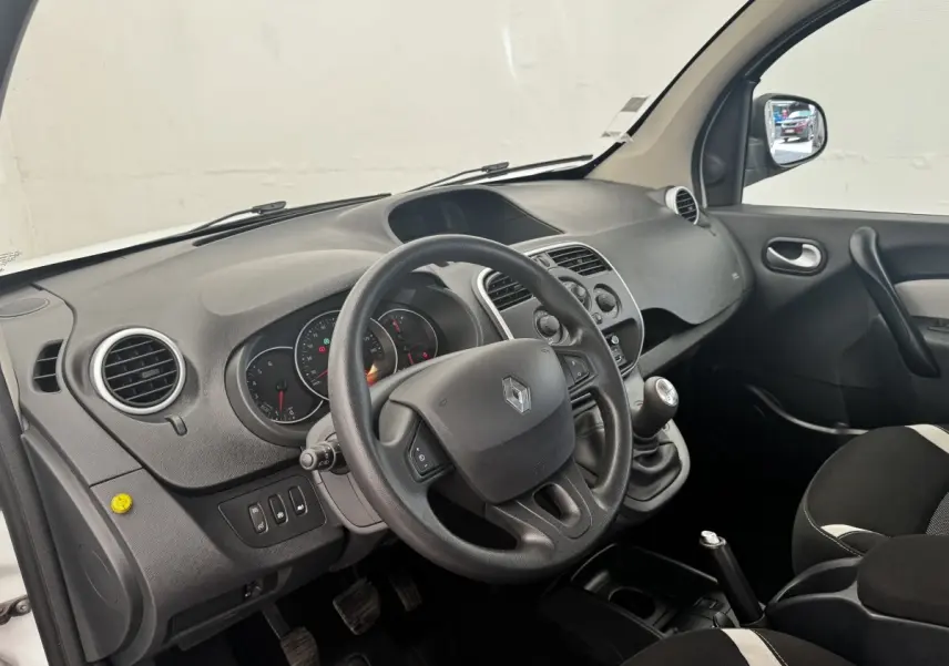 Vue intérieure côté conducteur du tableau de bord et volant multifonctions d’un Renault Kangoo blanc de 2016.