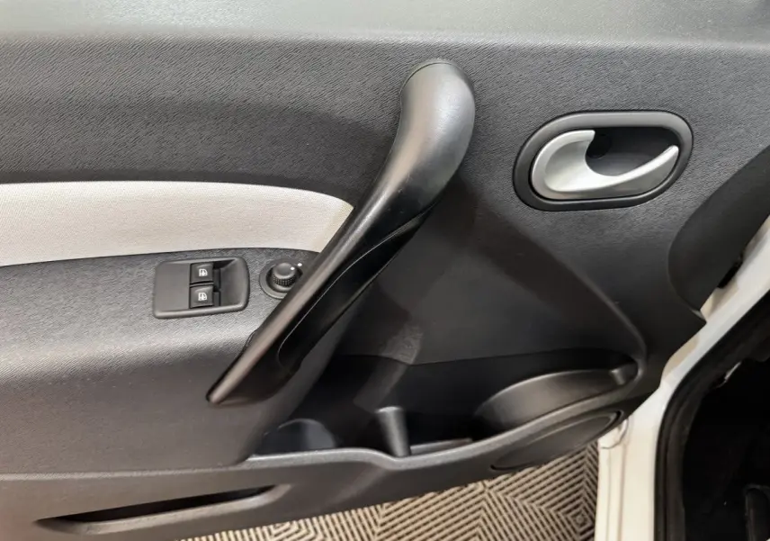 Vue rapprochée de la porte avant gauche blanche du Renault Kangoo Zen 2016, avec commandes de vitres et poignée noire.