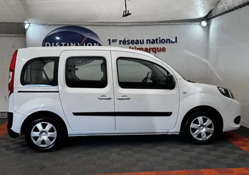 Profil latéral droit d’un Renault Kangoo blanc 2016, version Zen, dans un showroom intérieur.