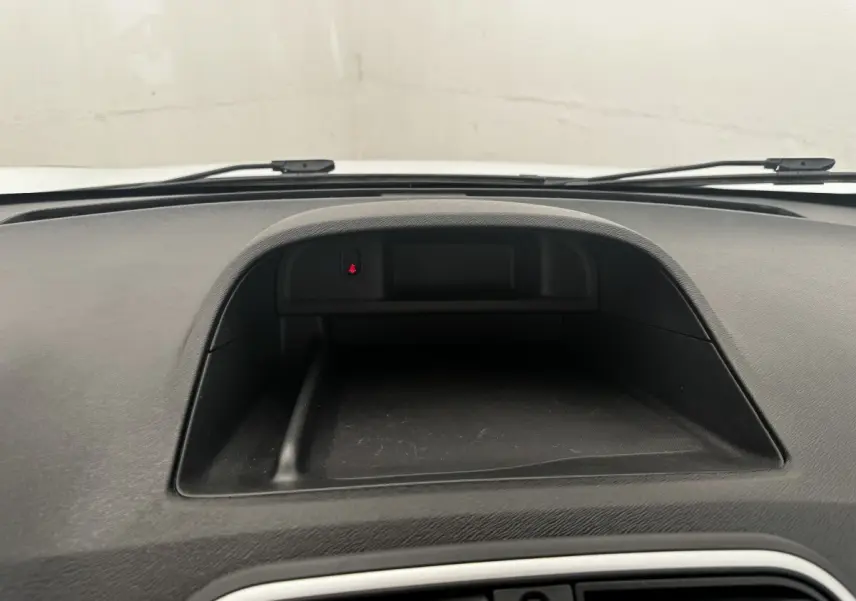 Vue rapprochée du tableau de bord noir du Renault Kangoo blanc 2016, avec espace de rangement intégré.