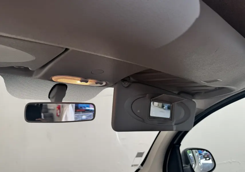 Intérieur du Renault Kangoo Zen 2016, vue sur pare-soleil avec miroir et rétroviseur central allumé.
